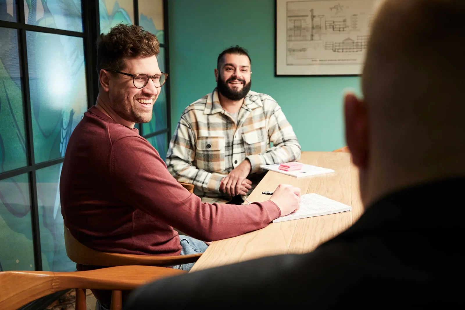 Two of the team laughing across the meeting-room table at RKH